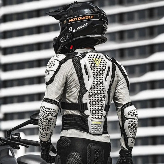 Motard de dos portant le gilet de protection moto blanc et son casque devant un immeuble