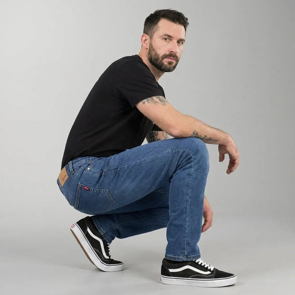Jean moto Asfalt bleu porté accroupi : le denim stretch suit le genou